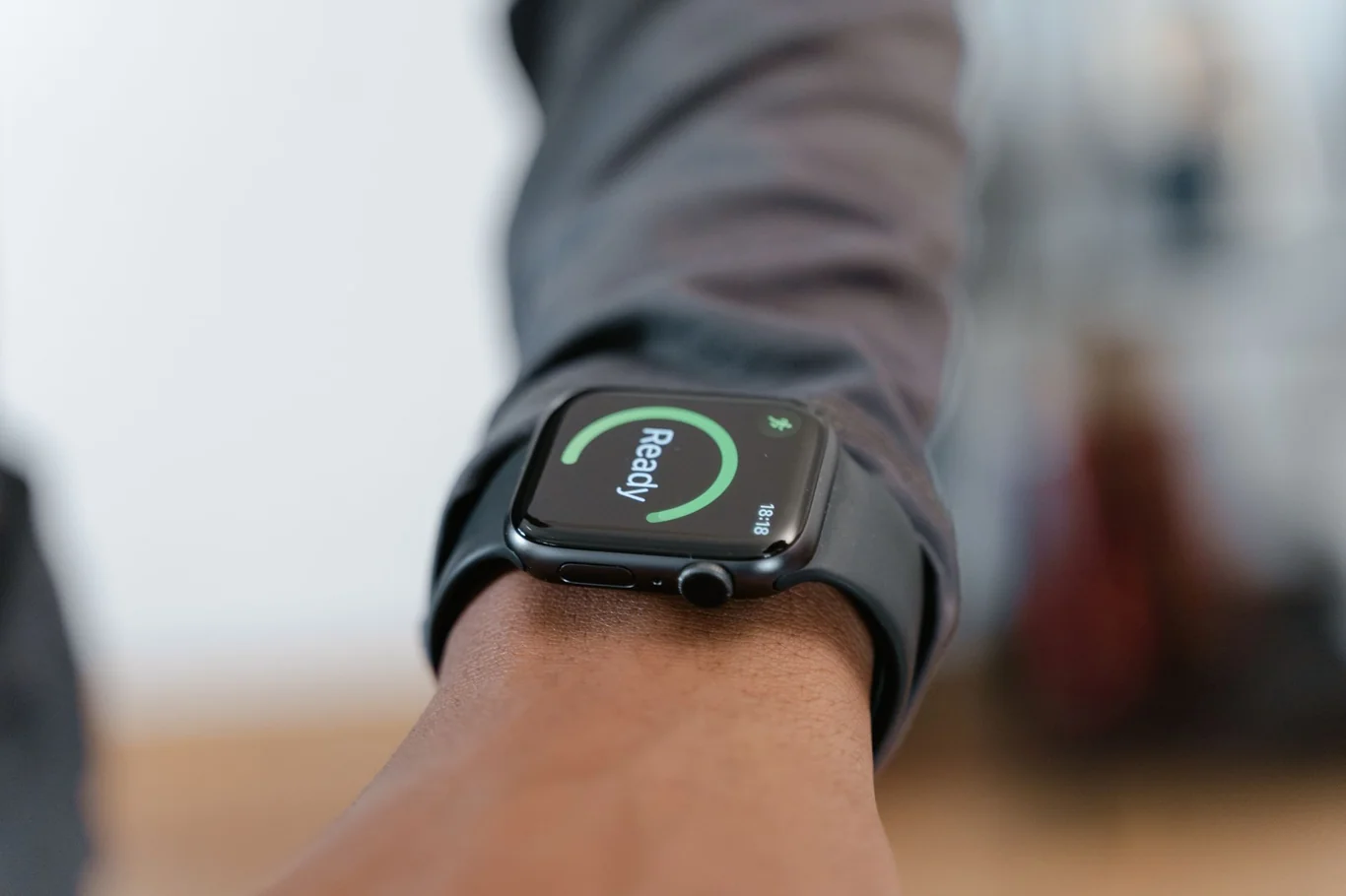 Apple Watch on a wrist displaying a green Ready screen against a blurred background