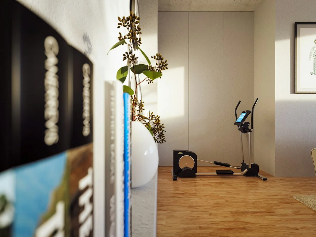 Elliptical machine in a bright home room with hardwood floors and white walls