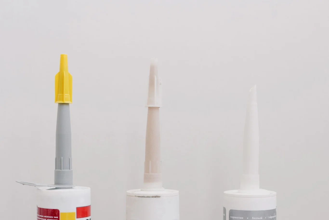 Three lubricant applicator tubes lined up against a white background
