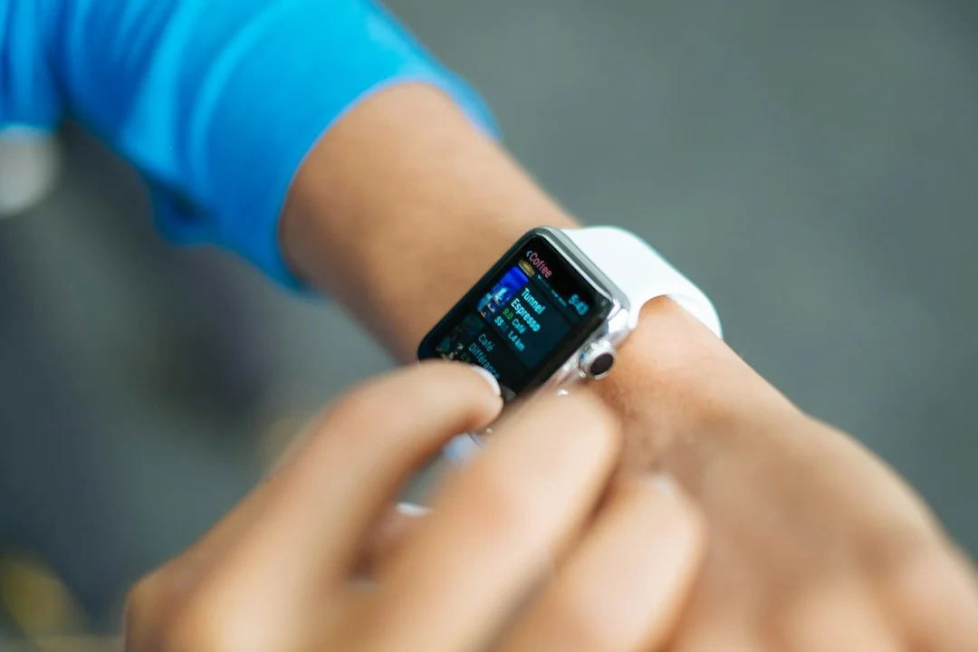 Person in blue workout top checking smartwatch fitness stats during exercise