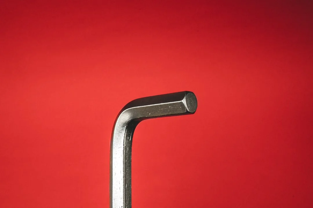 Silver Allen wrench against a red background