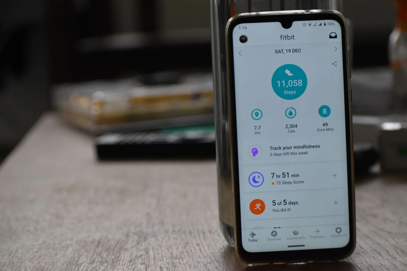 Android phone displaying the Fitbit app step count dashboard on a table