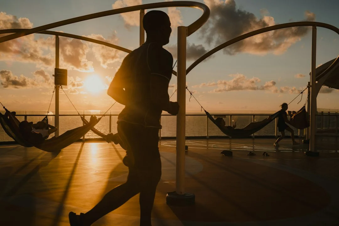 Man jogging outdoors at sunset with warm light in the background