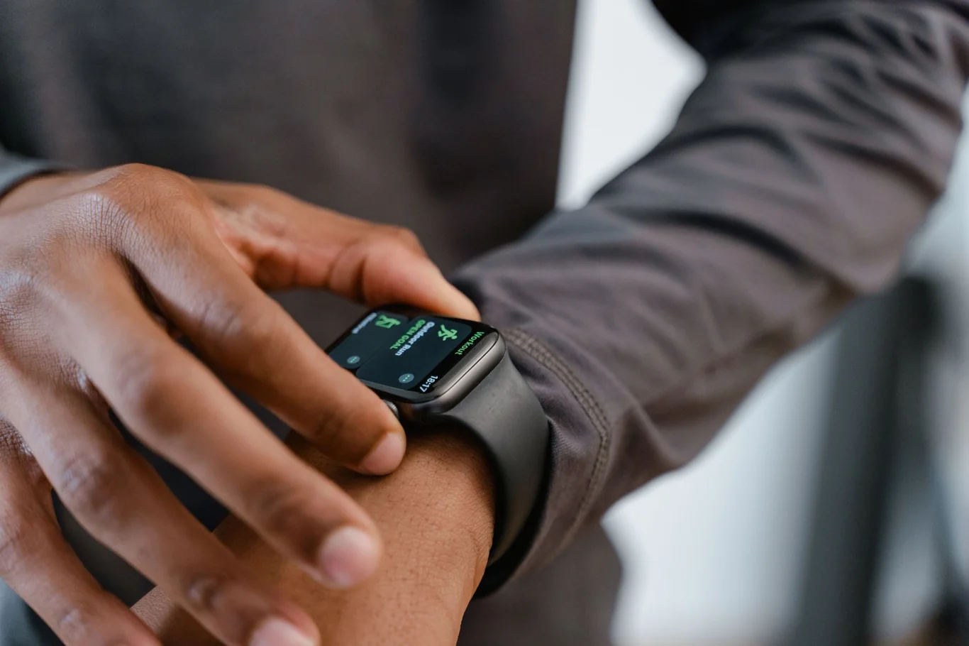 Person tapping a smartwatch displaying fitness stats during a workout
