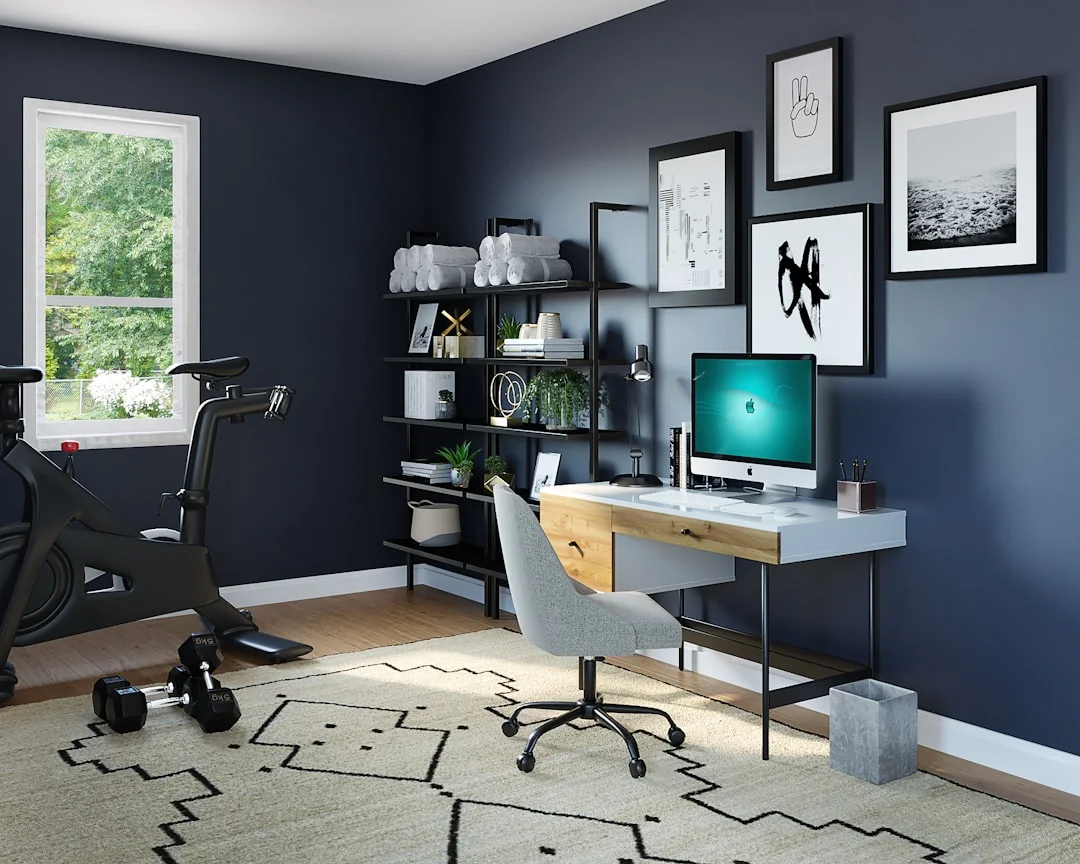 Indoor stationary bike and dumbbells set up in a home office corner