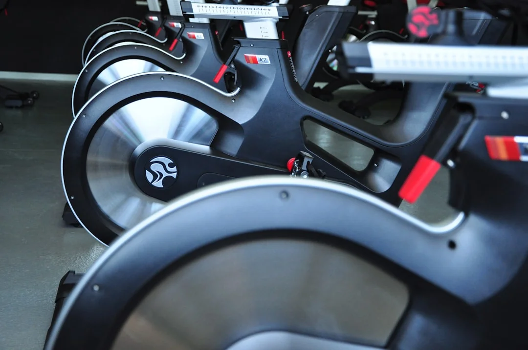 Row of black spin bikes lined up in an indoor cycling studio