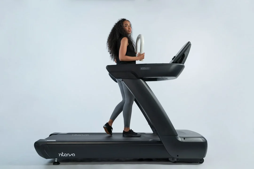 Woman jogging on a treadmill against a clean white background