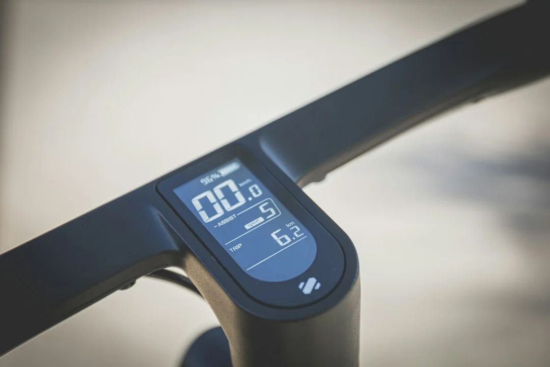 Close-up of a bike computer mounted on handlebars showing digital ride data