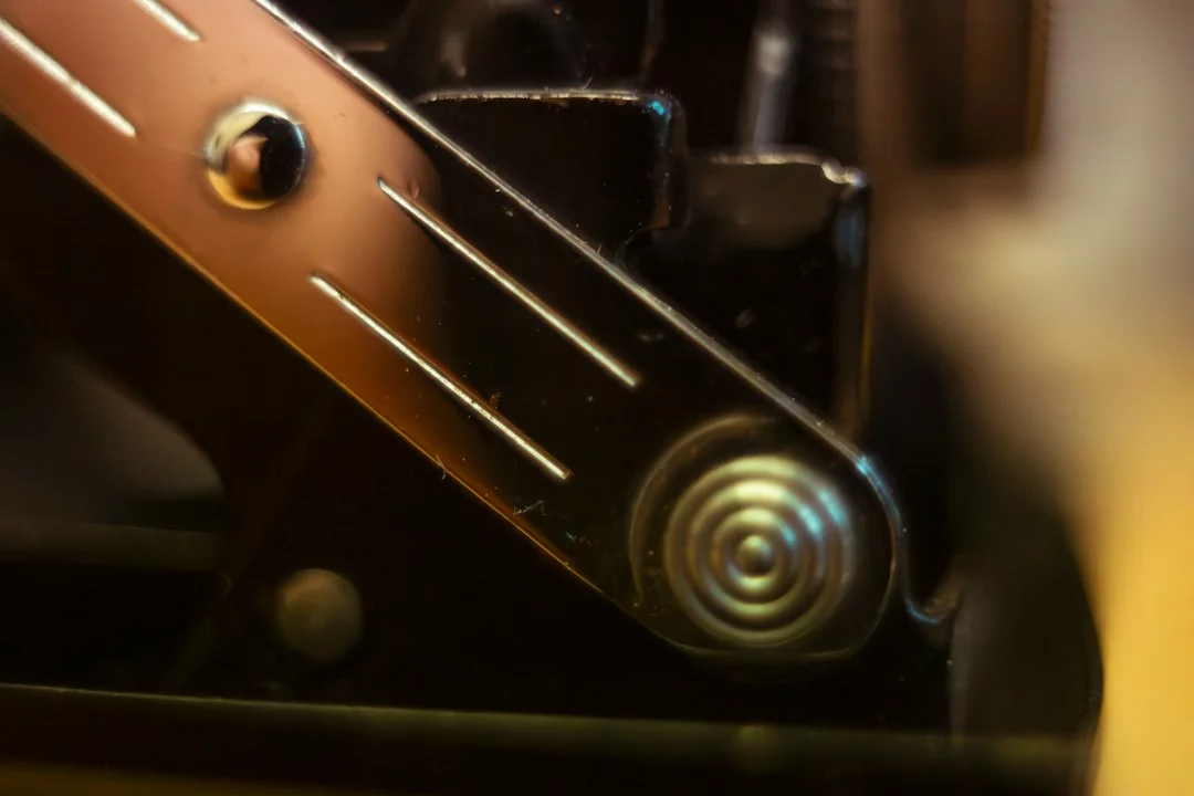 Metal pivot bolt and coil spring mechanism on an elliptical machine pedal track rail