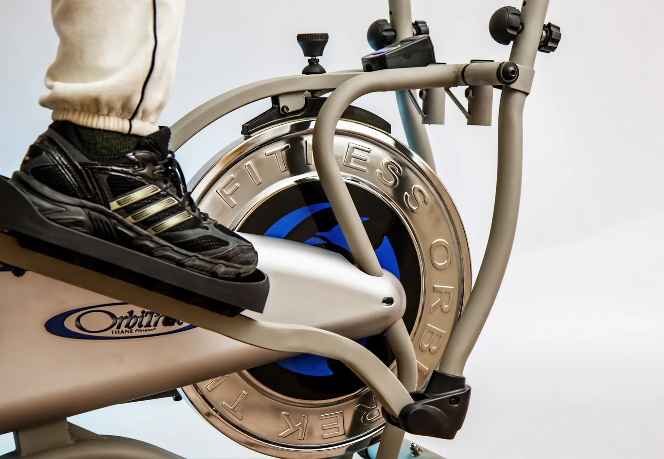 Close-up of a sneaker positioned on an elliptical machine pedal during a workout