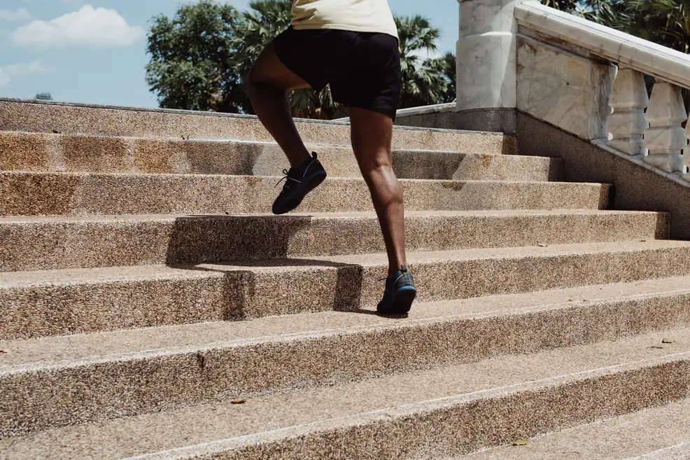 Man sprinting up granite outdoor stairs in natural sunlight