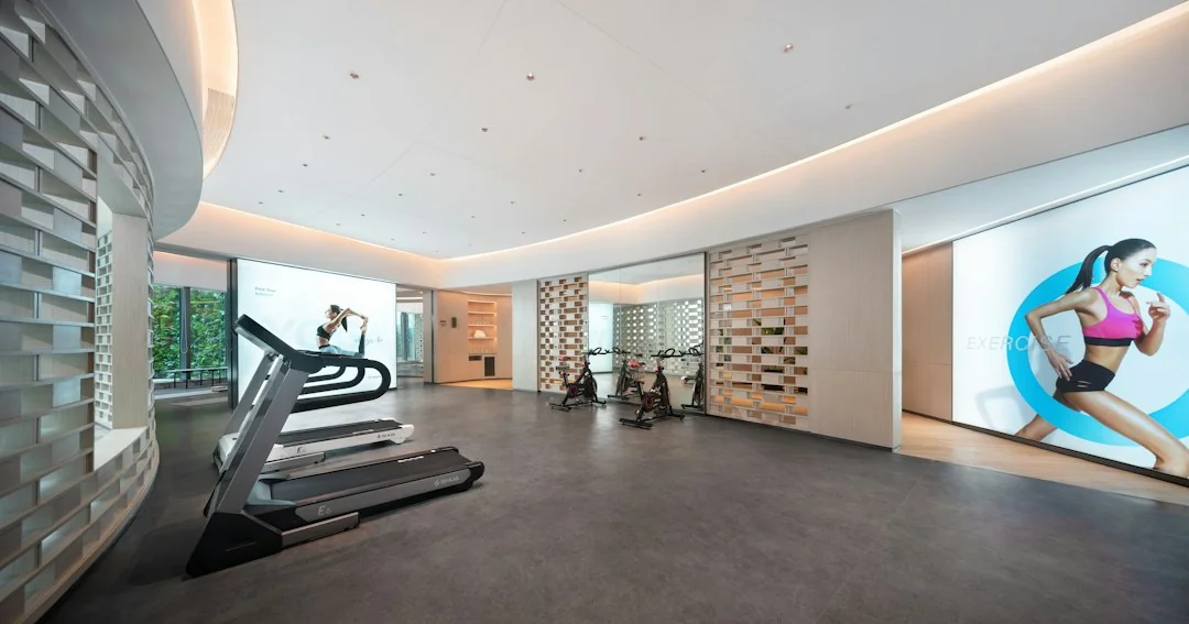 Modern gym interior with treadmills and cardio equipment along a curved wall