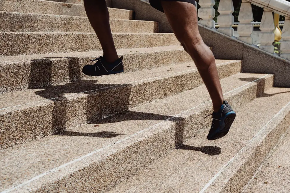 Person climbing outdoor stone stairs during a cardio workout