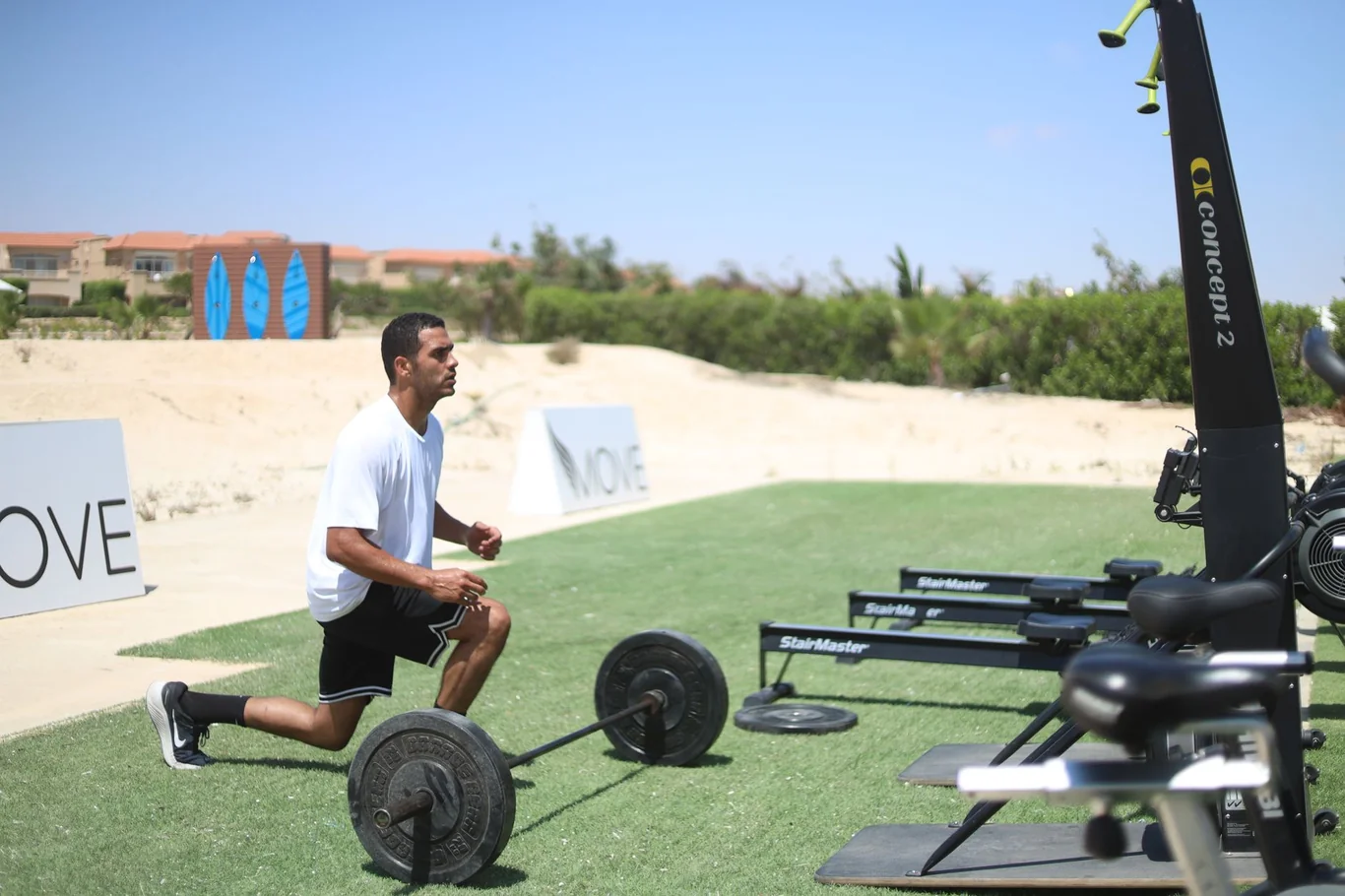 Athlete performing outdoor lunges beside StairMaster equipment during a high-intensity training session