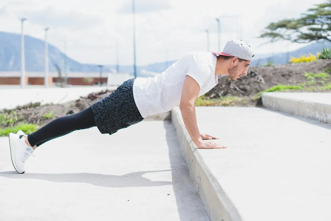 Man doing incline push-ups on a concrete ledge during an outdoor workout